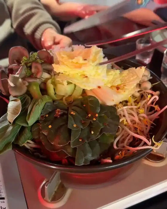 모츠나베 재료에 젓가락질하는 모습