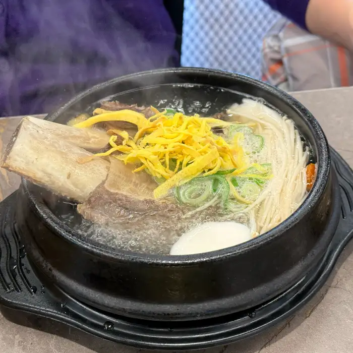김이 모락모락 나는 왕갈비탕. 큼직한 갈비대와 고명으로 올라간 계란 지단, 파채가 먹음직스럽습니다.