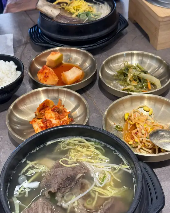 갈비탕 한 상 차림. 밥, 반찬, 그리고 갈비탕이 함께 놓여 있습니다.