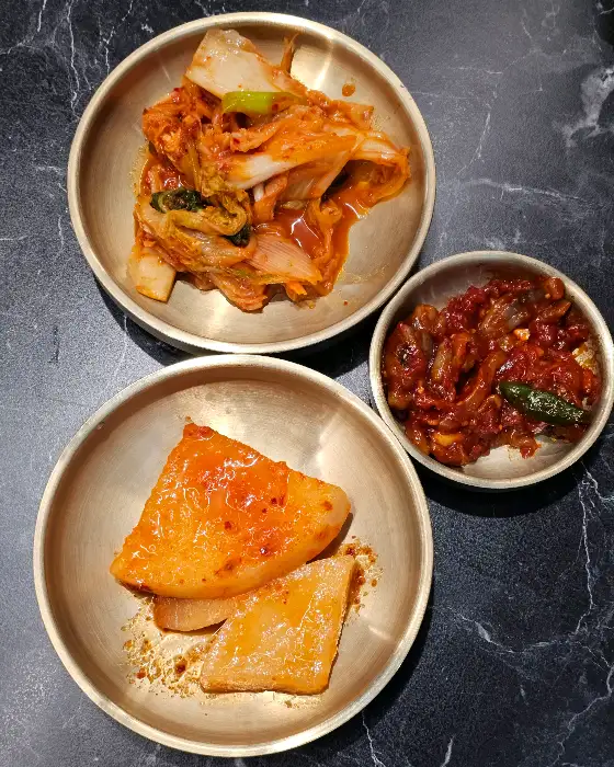 김치, 깍두기, 그리고 콩나물무침이 담긴 앞접시.