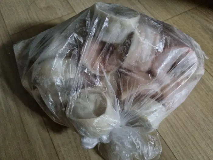 투명한 비닐봉투 안에 여러 개의 하얀색 어묵 조각들이 들어 있습니다. 어묵들은 둥근 모양이며, 일부는 겹쳐져 있습니다.