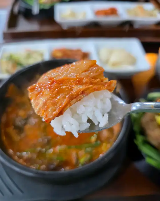 밥 위에 김치 한 점을 올려 먹는 모습