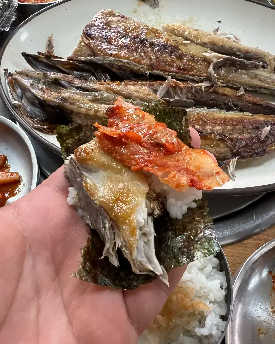 김에 밥과 생선살, 김치를 얹어 먹는 모습
