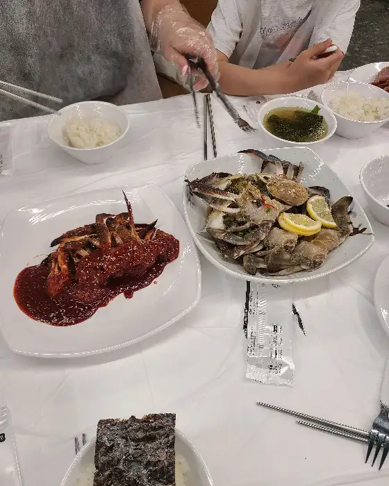간장게장, 양념게장, 밥, 국이 함께 차려진 식사 테이블