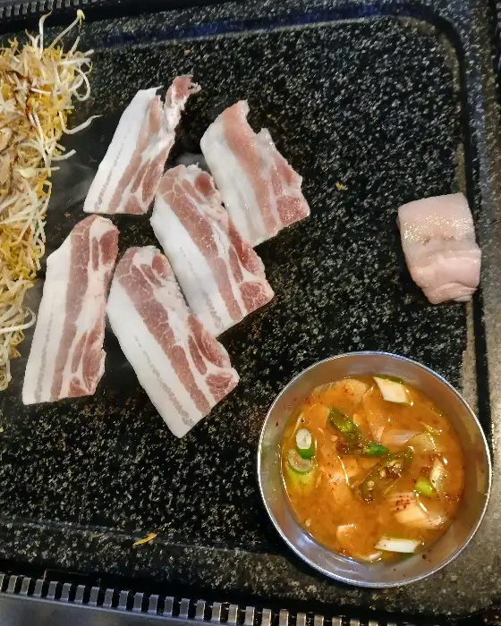 왕돌판 위에서 구워지고 있는 삼겹살과 항정살