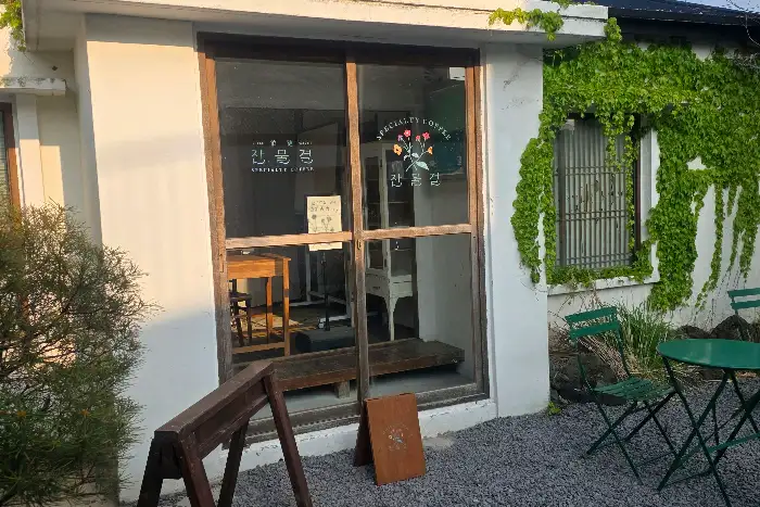 카메라를 들고 있는 사람의 모습. 배경에는 노란 유채꽃밭이 펼쳐져 있습니다.