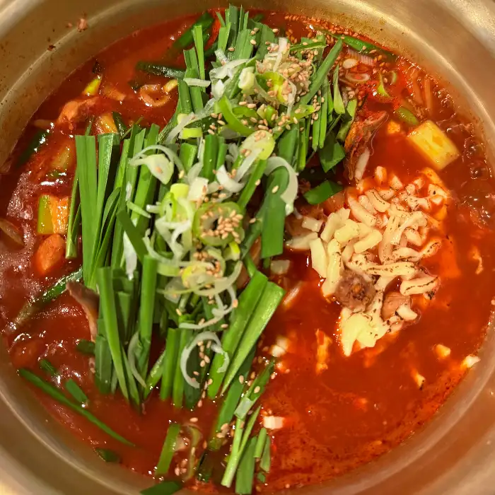 붉은 국물의 닭볶음탕에 치즈가 녹아내린 모습. 푸짐한 비주얼이 인상적입니다.