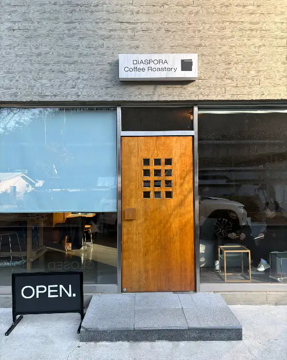 카페 입구, 'OPEN' 간판과 나무 문