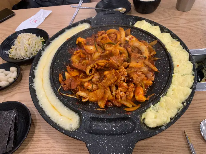 치즈와 계란찜이 둘러싸인 철판 요리