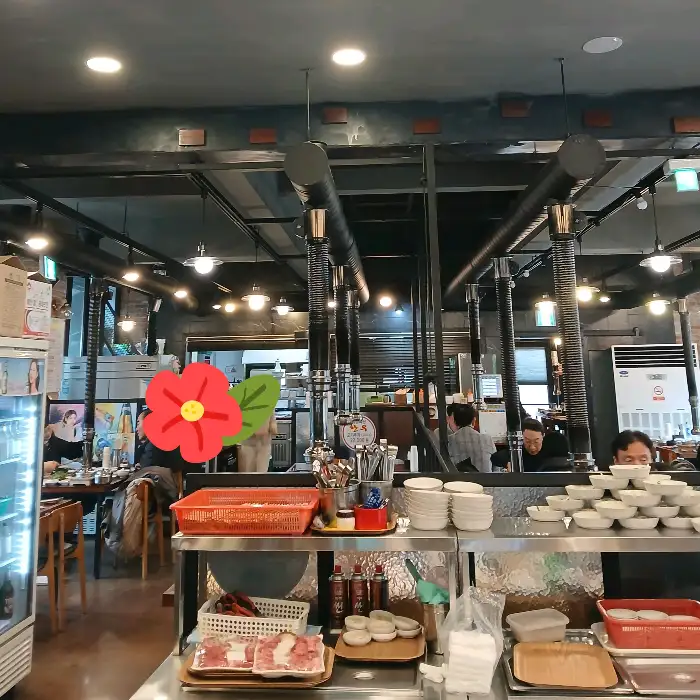 식당 내부 전경, 테이블과 숯불 연통이 보인다