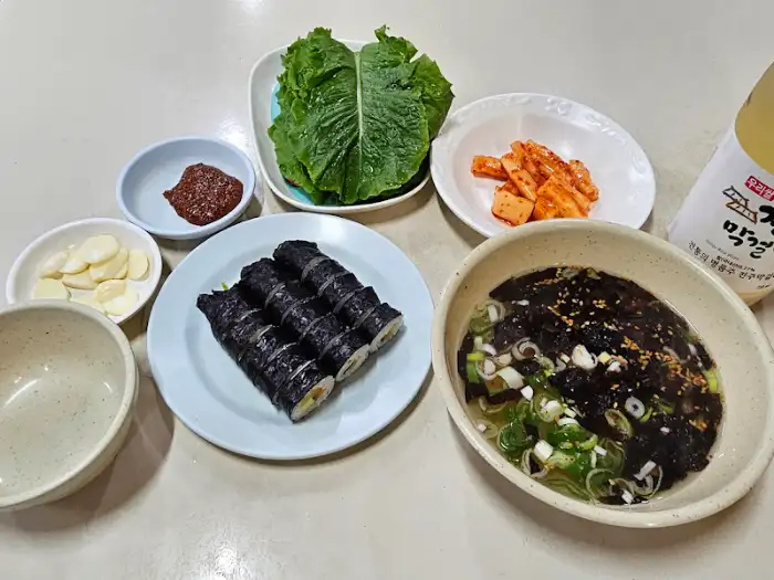 김밥, 콩나물, 김치, 쌈채소가 함께 나온 상차림