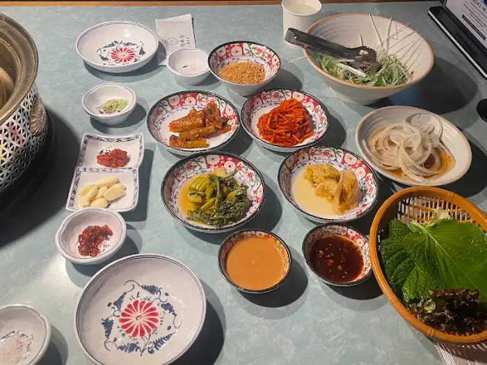 테이블 위에 차려진 다양한 반찬들과 쌈채소
