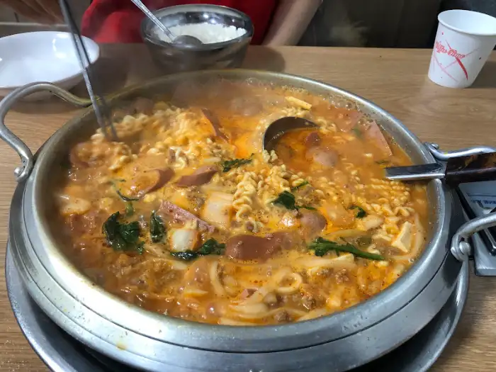끓고 있는 부대찌개와 젓가락질