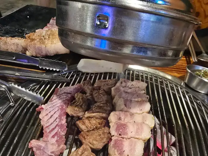 숯불 위에서 맛있게 익어가는 두툼한 숙성 돼지고기
