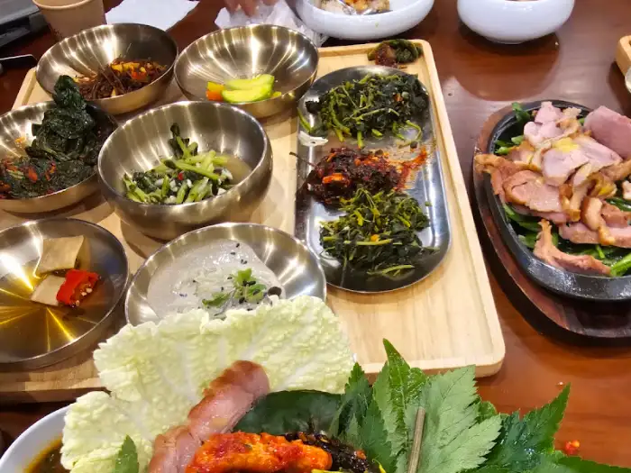 테이블에 차려진 여러 가지 나물 반찬과 쌈 채소
