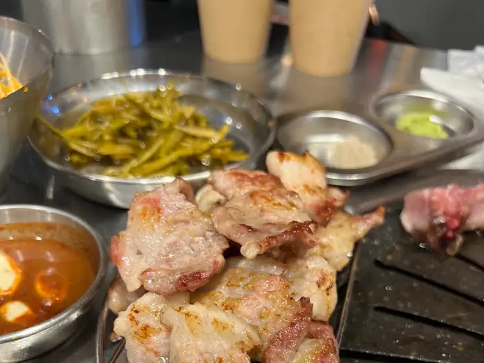 식탁 위에 놓인 반찬들과 갓 나온 고기 모습