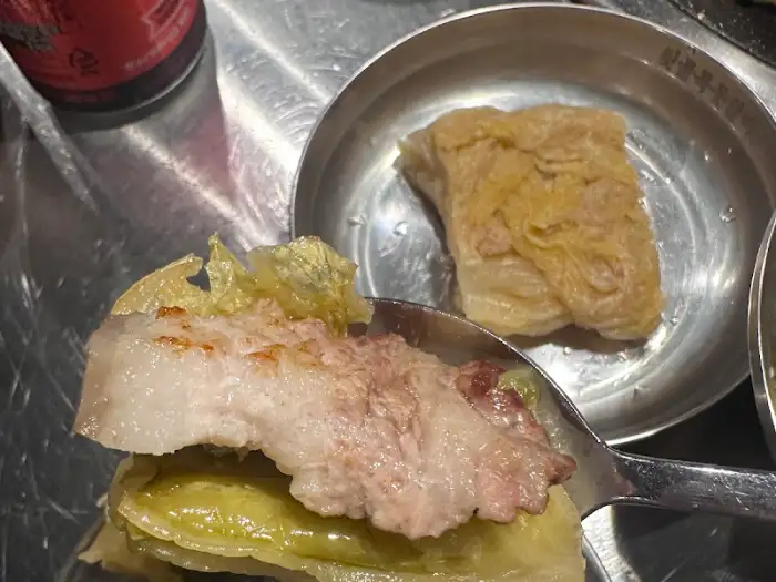 스푼으로 집어 올린 잘 구워진 돗갈비 조각