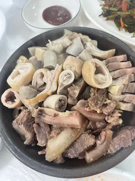 김치, 수육, 그리고 곁들임 반찬이 함께 담겨 있는 모습.