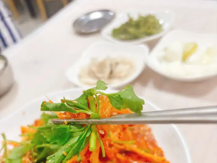 집게로 찜 요리 재료를 집어 올리는 모습
