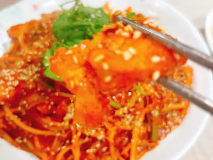 집게로 집어 올린 찜 요리 한 점