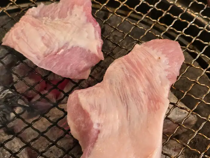 숯불 위에서 구워지는 두툼한 갈매기살 조각