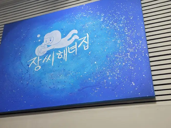 푸른색 배경에 흰색 로고가 그려진 간판 또는 메뉴판