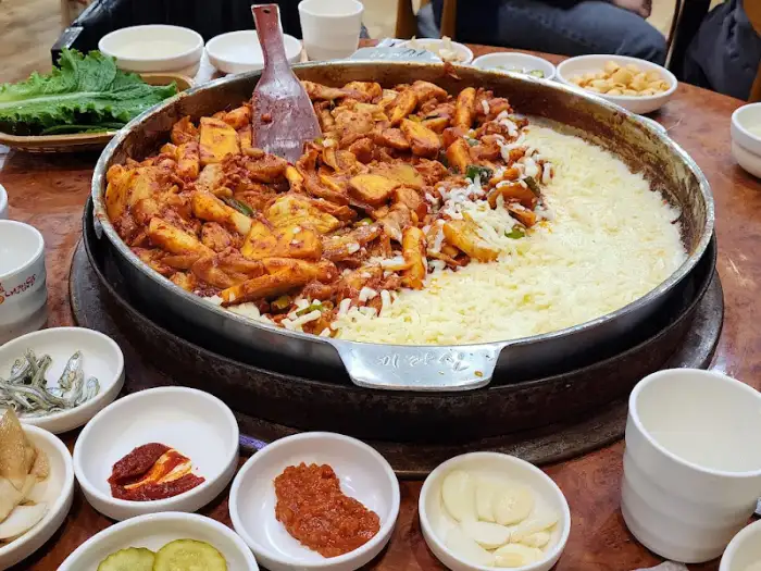 철판 닭갈비와 밥, 각종 반찬들이 준비된 모습
