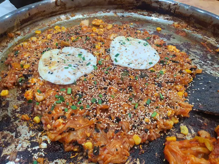 치즈가 녹아내린 닭갈비 볶음밥 위에 계란 프라이가 올려진 모습