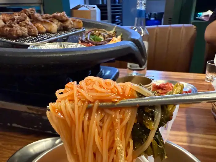 잘 구워진 삼겹살 한 점을 집는 모습