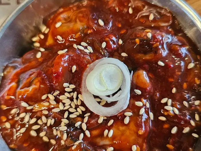 양념된 요리 위에 참깨와 파가 뿌려진 모습