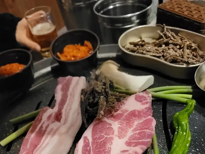 숯불 위에 올려진 고기와 함께 준비된 반찬들