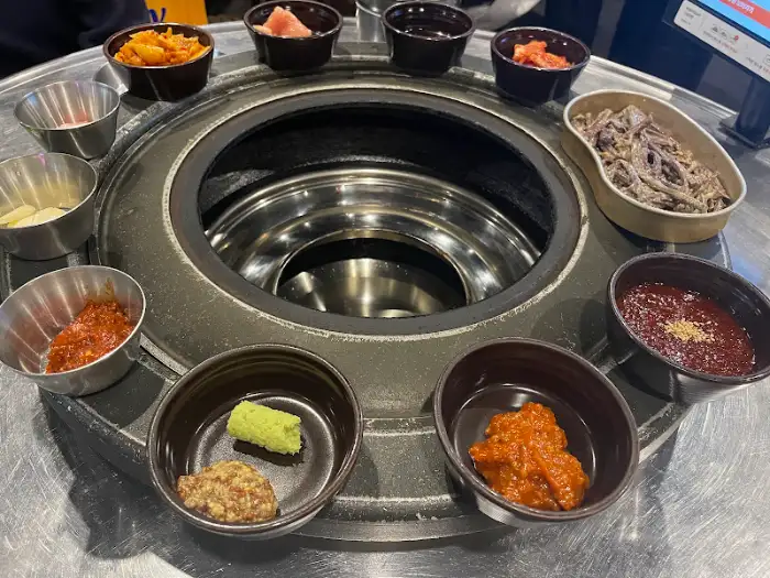 식탁 위에 놓인 다양한 고기, 소스, 밑반찬의 전체 모습