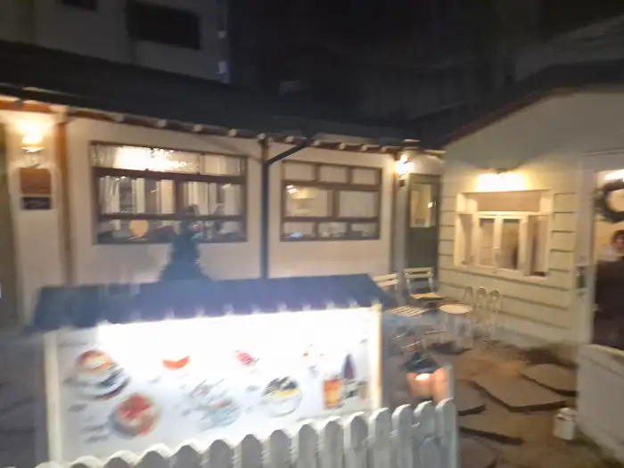 카페 마리의 야외 공간. 늦은 밤에도 운영되는 카페의 따뜻한 불빛이 보입니다.