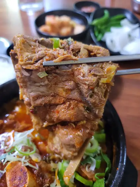 젓가락으로 뼈해장국 살코기를 집어 올린 모습
