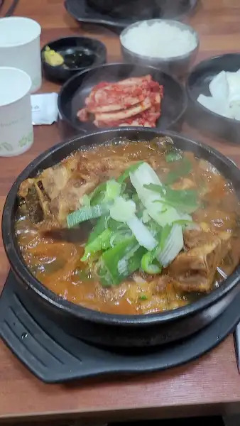 식탁 위에 놓인 뼈해장국과 곁들임 반찬들
