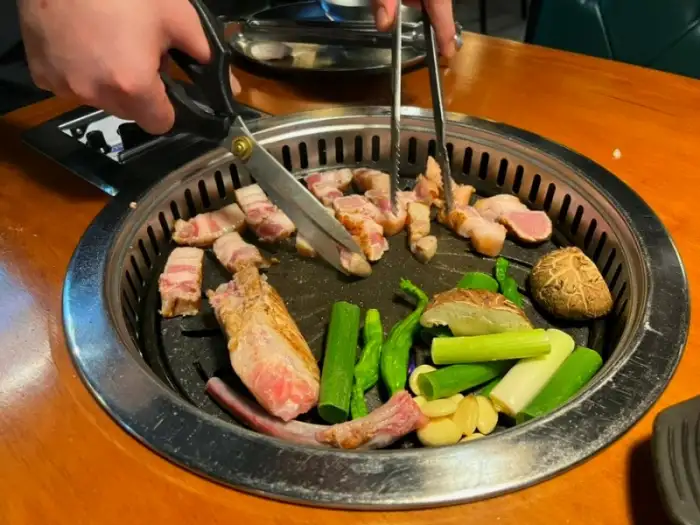 가위와 집게로 고기 굽는 모습