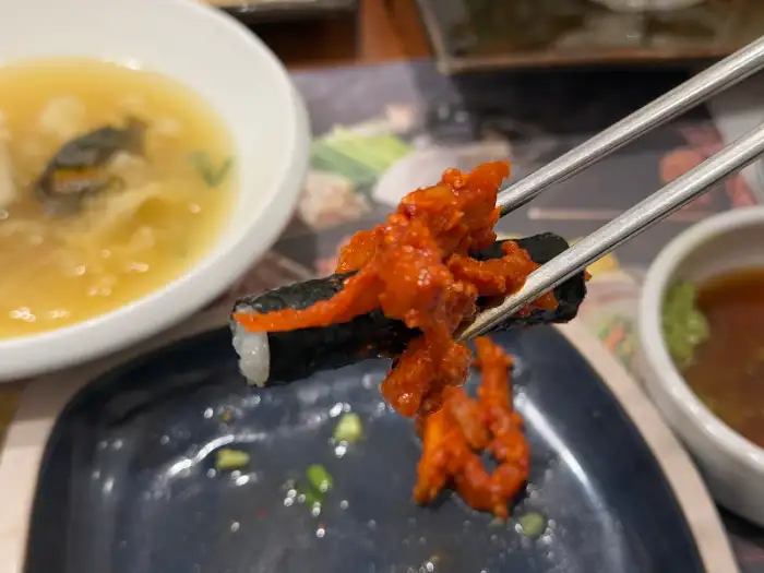 젓가락으로 집어 올린 매콤한 복어 조각