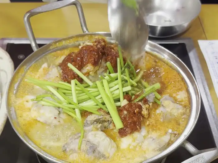 끓고 있는 복어 매운탕에 채소를 더하는 모습