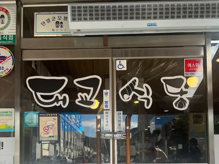 식당 외관의 모습. 간판에 여러 그림과 글씨가 적혀 있다.