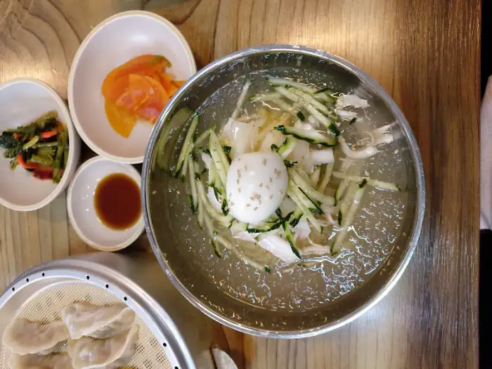 초계국수. 맑은 육수에 닭고기, 오이채, 달걀이 올라가 있는 모습.