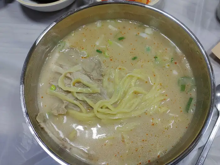 꼬막 비빔밥 클로즈업. 꼬막의 윤기와 채소의 신선함이 돋보인다.