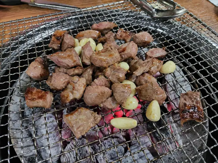 숯불 위에서 익어가는 갈매기살과 마늘