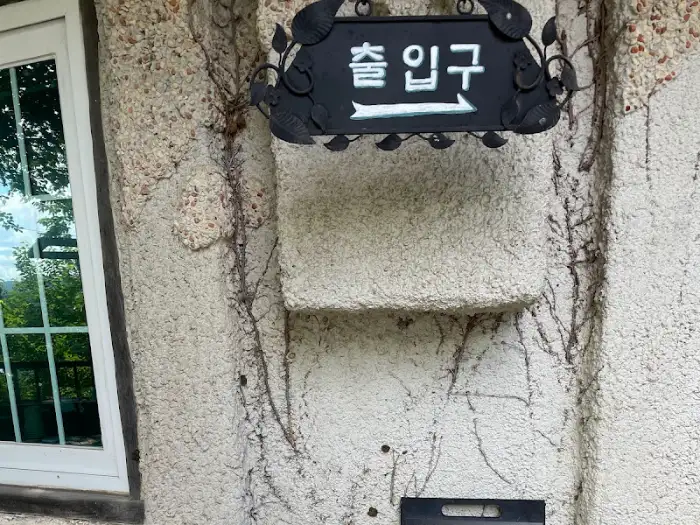 돌담에 걸린 독특한 디자인의 '출입구' 표지판