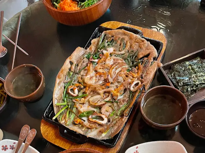 철판 위에 올려진 노릇하게 구워진 해물파전