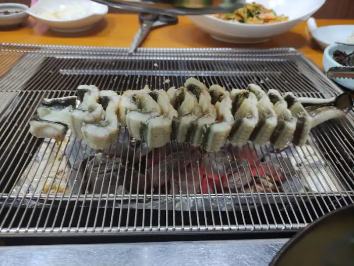 숯불 위에서 익고 있는 장어 조각들 (다른 각도)