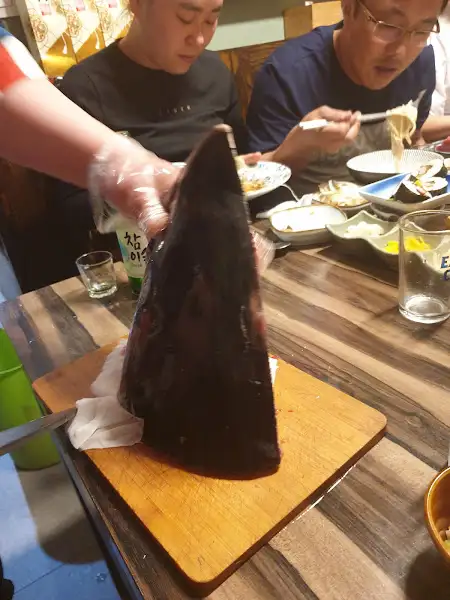 직원이 참치 머리를 들고 있는 모습