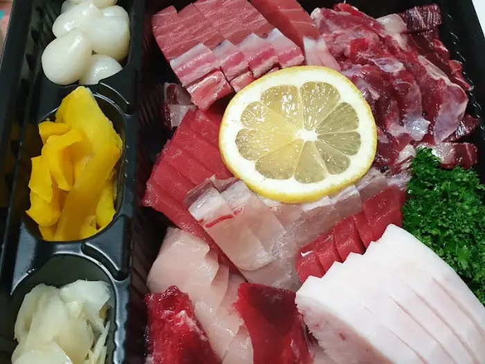 신선한 참치회 조각들과 레몬, 곁들임 재료들