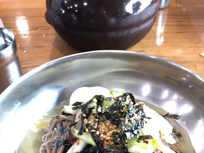 막국수 클로즈업, 김가루와 참깨가 뿌려져 있음