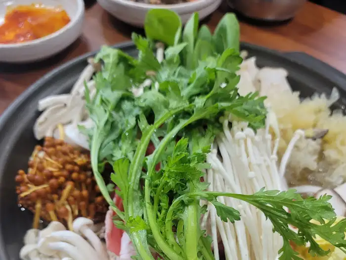 전골 냄비 안의 푸짐한 버섯과 채소