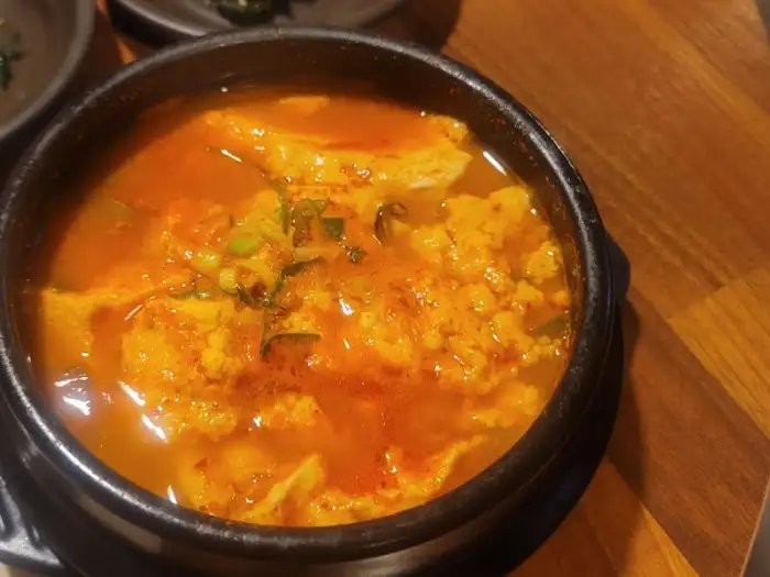 순두부찌개 근접 촬영, 부드러운 순두부와 얼큰한 국물이 돋보이는 모습